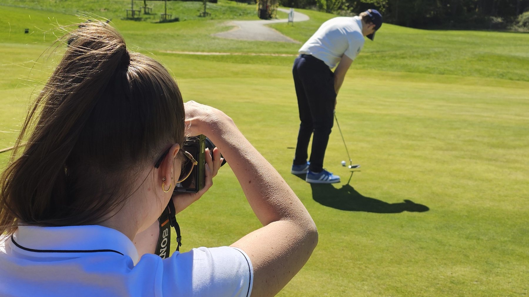 Alina fotografiert einen Golfer beim Putt