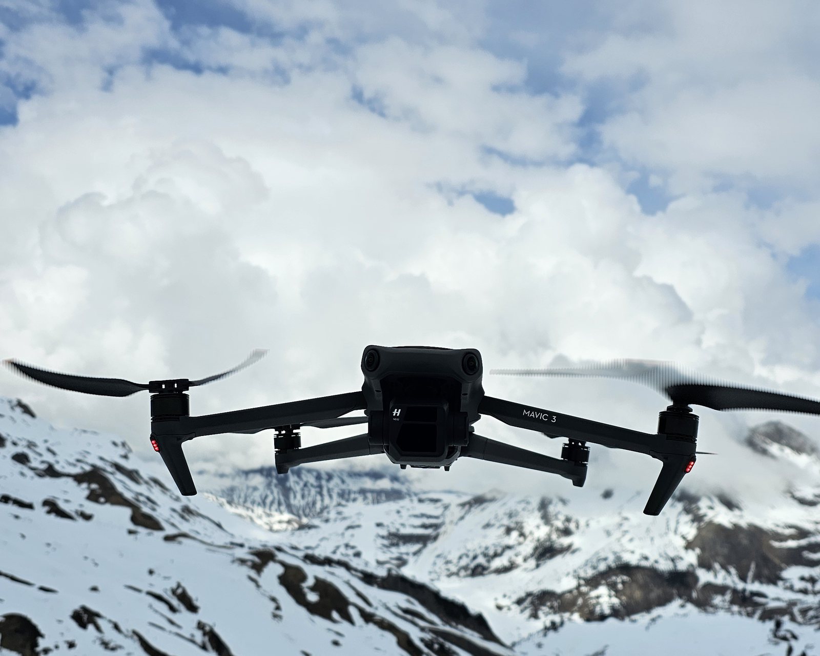 DJI Mavic 3 schwebt vor Wolkenkulisse in den Alpen
